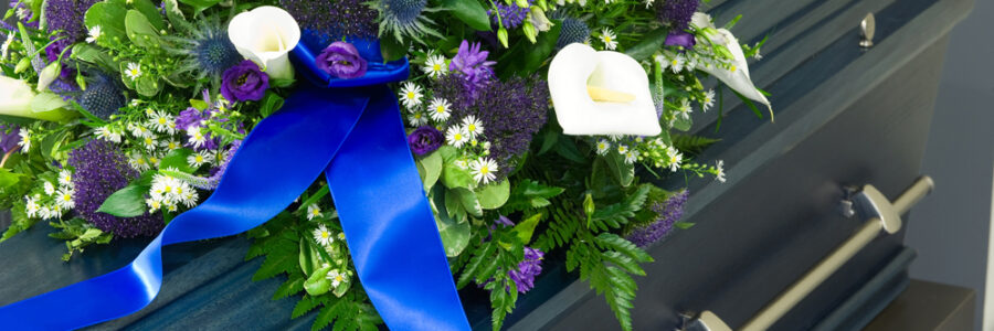 A blue coffin in a morgue with a flower arrangement